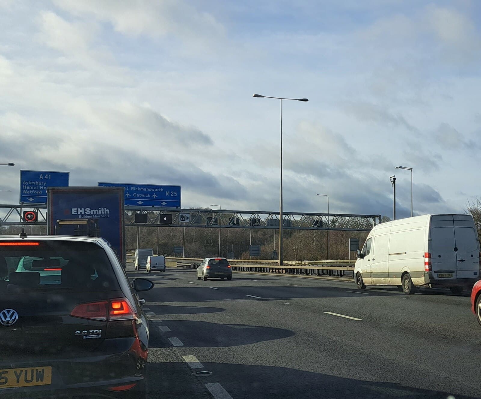 Cars, a delivery van and a lorry queueing in traffic to leave the M25 motorway at Junction 20, Hertfordshire, England.
