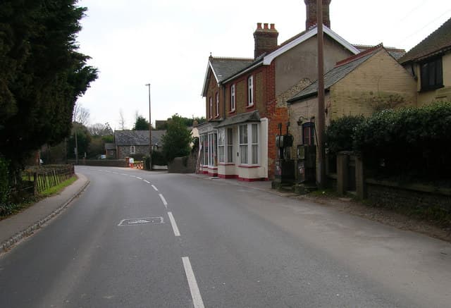 Preserved vintage petrol pumps outside a village shop on Yapton Road, West Sussex, England.